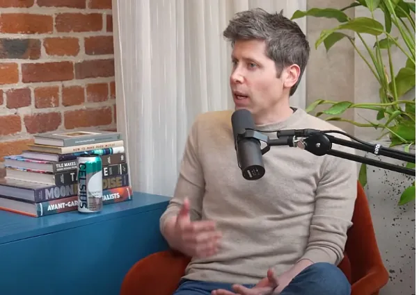 Person discussing AI topics in a podcast interview setup with books and microphone