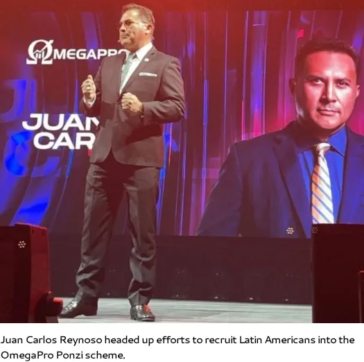 Juan Carlos Reynoso speaking on stage at an OmegaPro event, recruiting Latin Americans into the Ponzi scheme