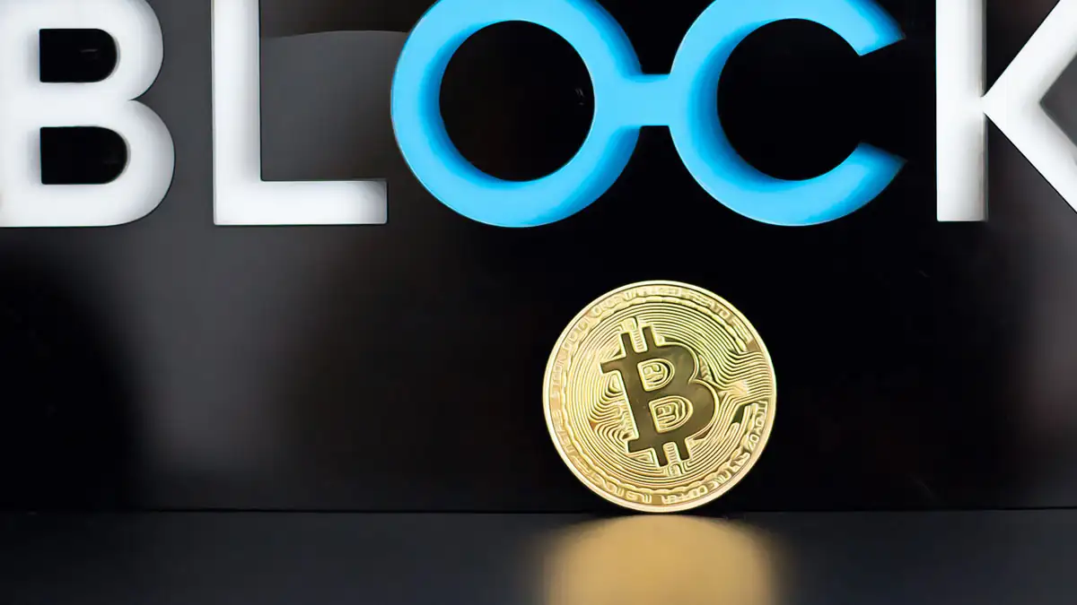 Bitcoin coin in front of block sign symbolizing volatility after Fed minutes