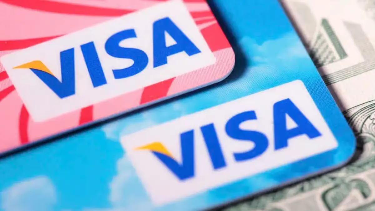 Visa debit and credit cards placed on US dollar bills representing crypto payments and digital finance