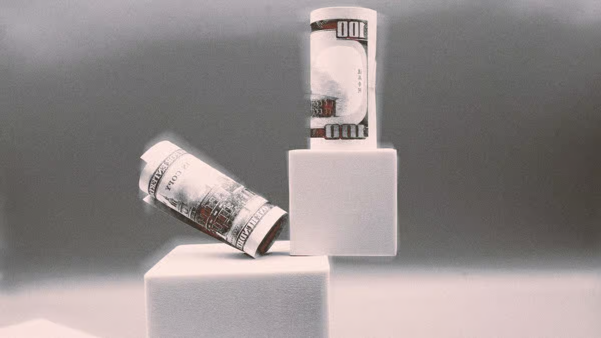 Rolled U.S. dollar bills placed on white blocks representing frozen USDT assets linked to Iran and Tether wallets.
