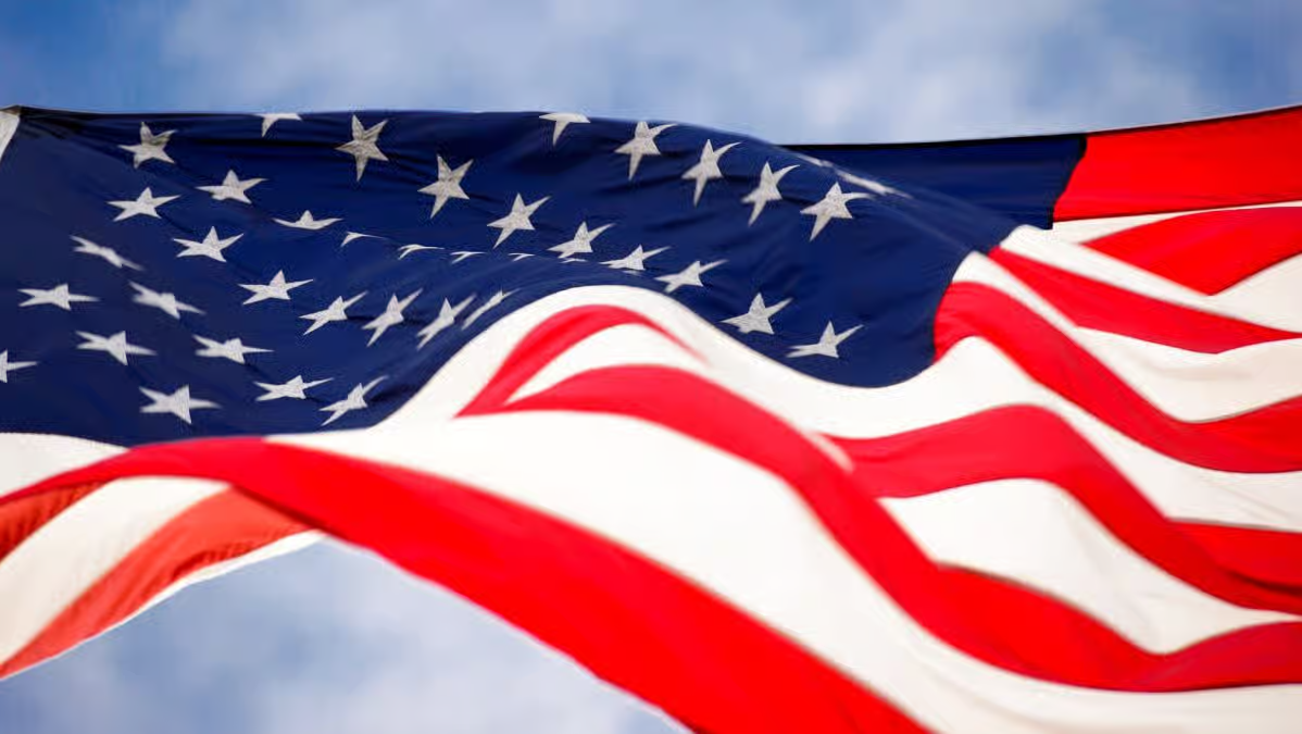 High quality American flag waving in the sky with vibrant red white and blue colors