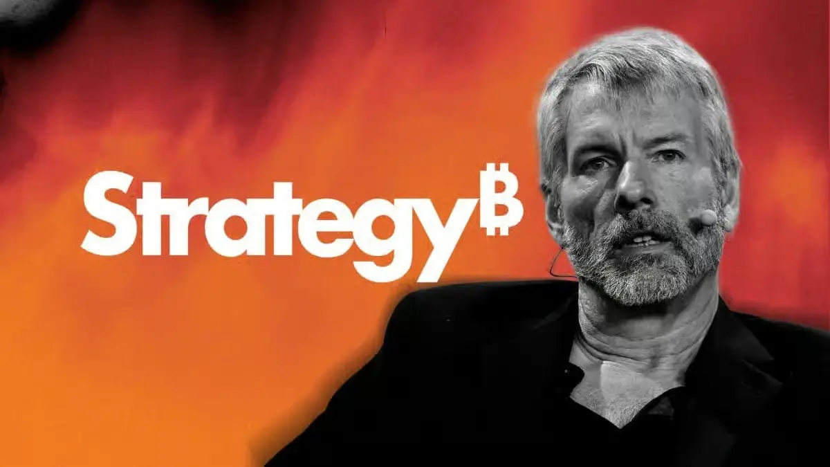Michael Saylor speaking in front of the Strategy logo after hinting at another possible Bitcoin purchase following four weeks without a Strategy Bitcoin buy.