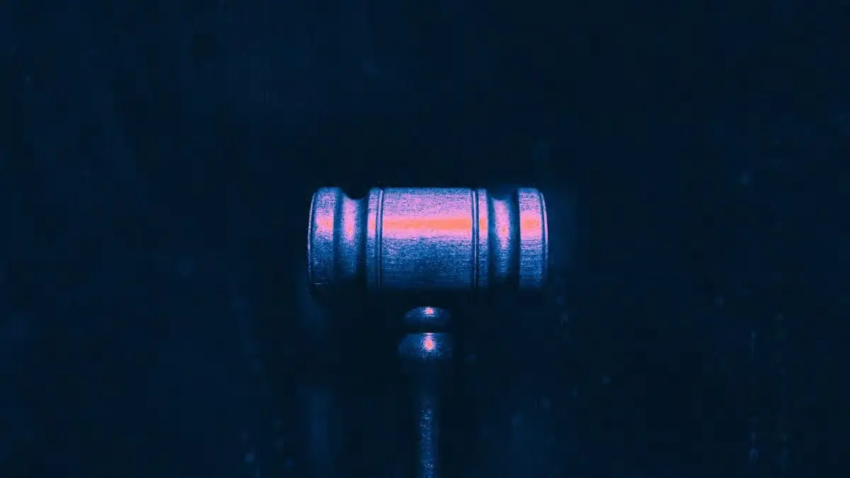 Wooden judge gavel with glowing light effect on dark blue background representing CFTC Kalshi fine and regulatory enforcement