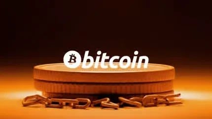 Bitcoin logo superimposed over stacked gold coins and a chain on a warm amber background.